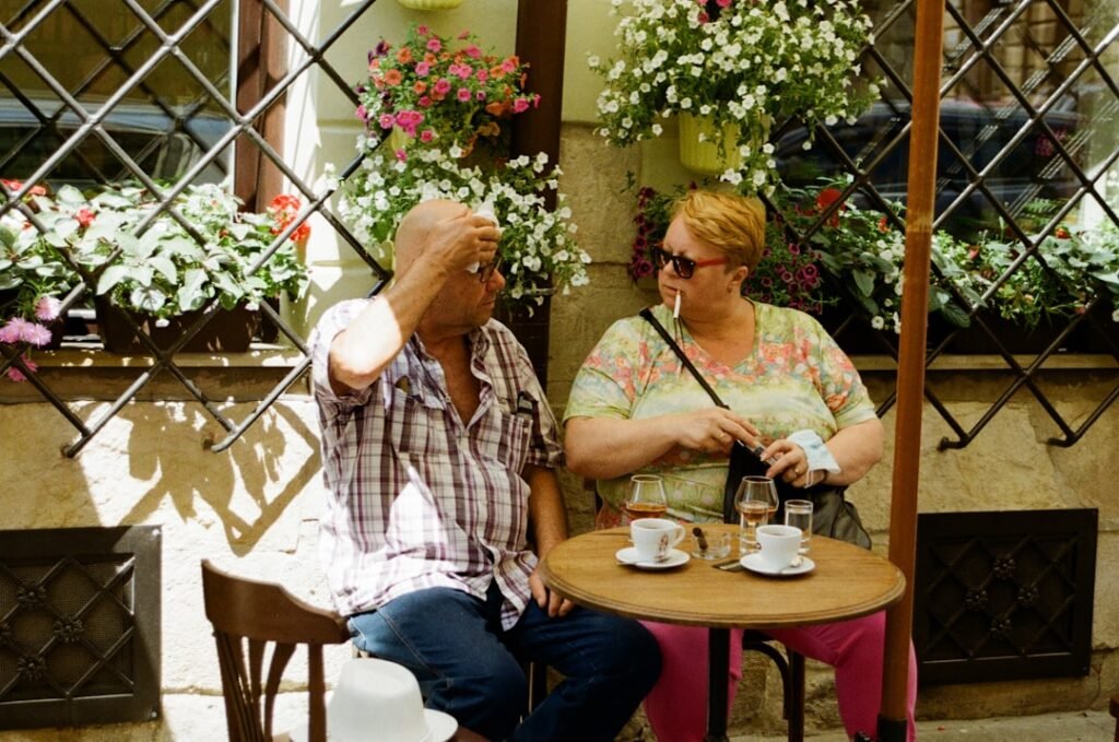 Two people having a conversation at an outdoor cafe, representing real-world Spanish language communication and cultural immersion
