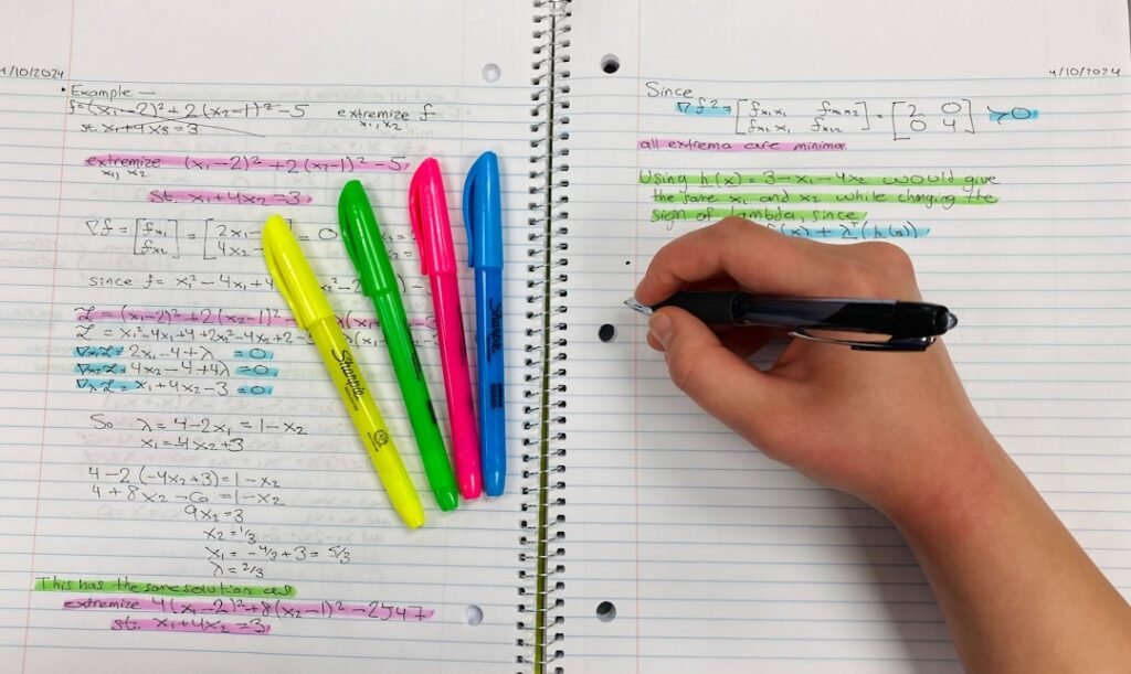 Student taking organized notes with colorful highlighters and pen during a focused study session